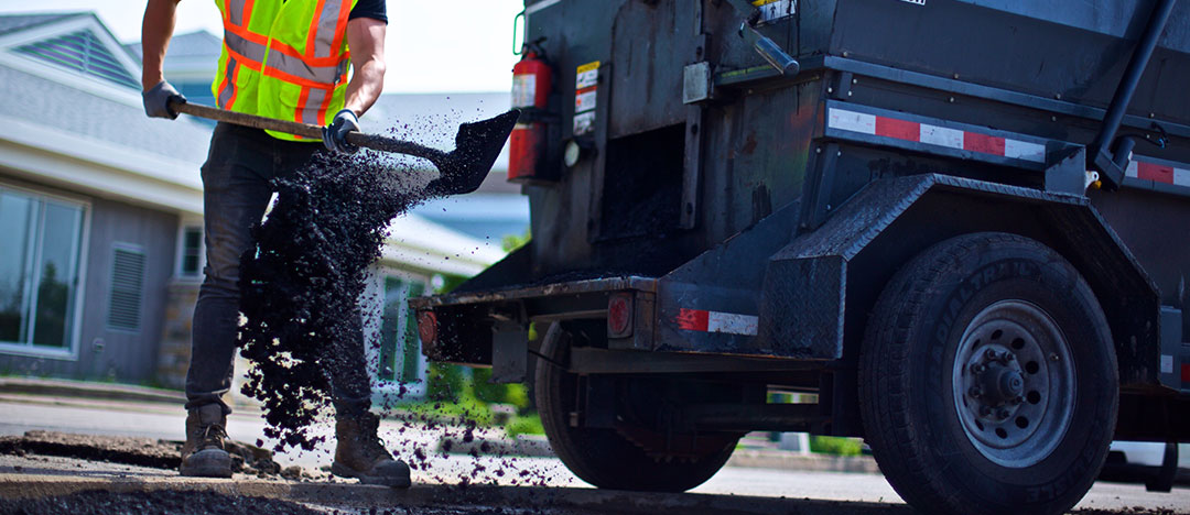 shoveling asphalt from the hmt4000odl shoveling platform in the hole