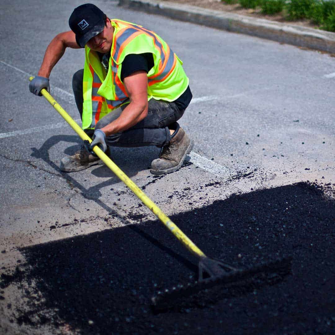 Canadian Property star worker spreading asphalt